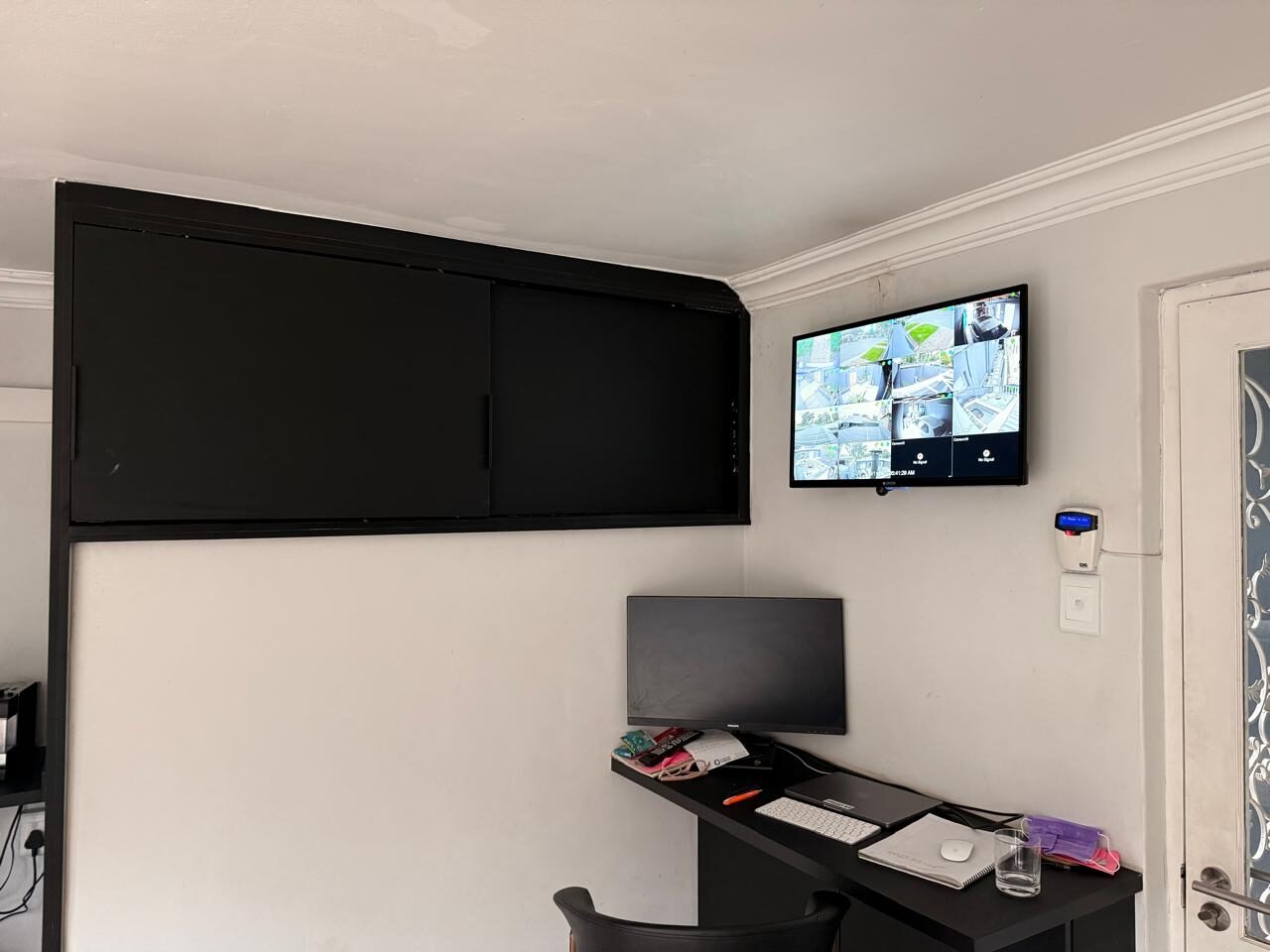 Wall-mounted CCTV monitor displaying a live multi-camera security feed