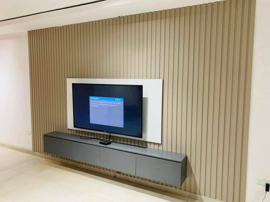 DStv decoder showing a no-signal notification on a mounted TV, possibly due to weather or a connection fault
