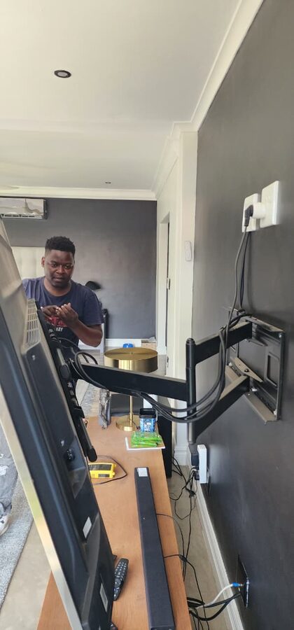 Technician working on a TV wall mount installation