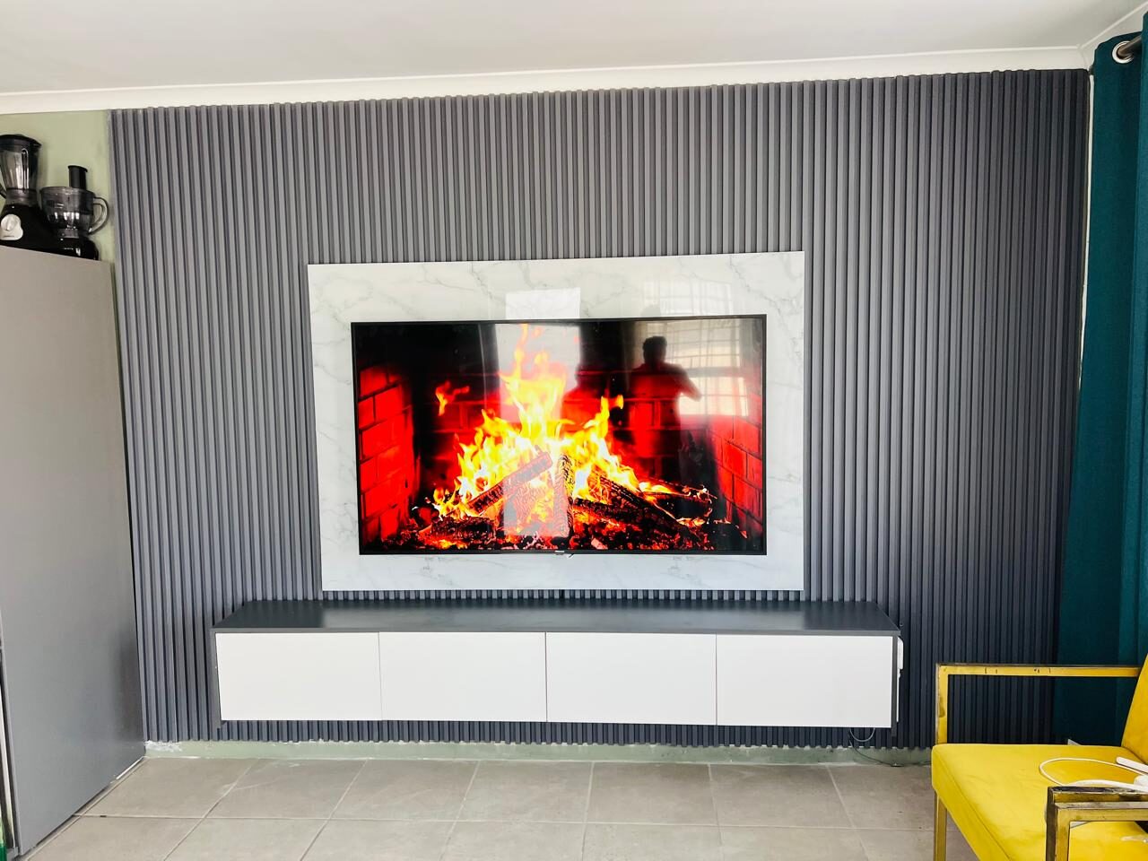 Finished TV wall mount on a slat-panel accent wall with fully concealed cables